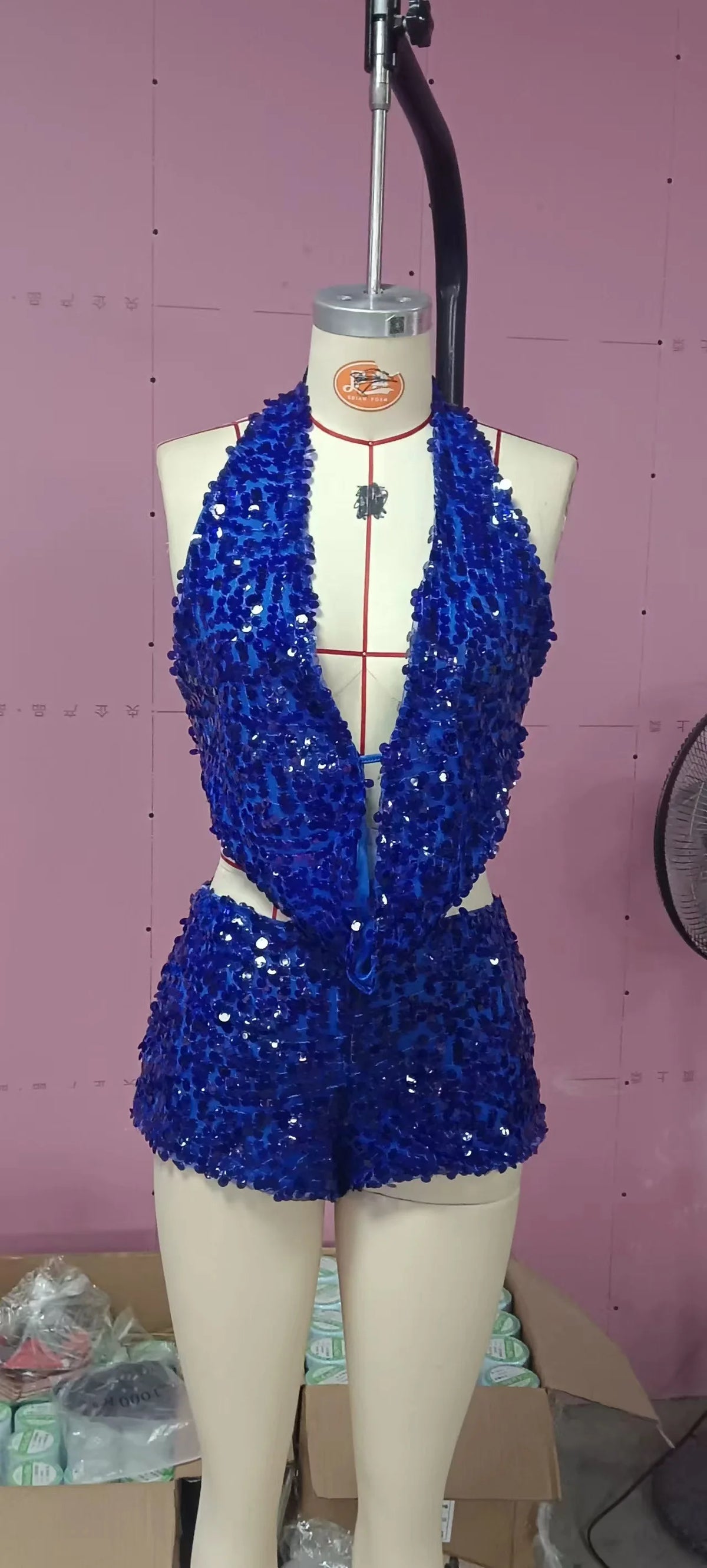 Two-piece sexy sequined outfit with sleeveless top and matching bottom, featuring shiny silver embellishments.