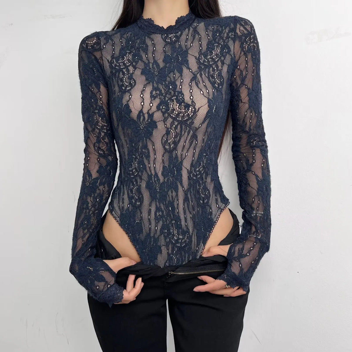 Woman wearing a mid-high neck, long-sleeve body suit by Corporación Turística, close-up of the stylish, fitted design.