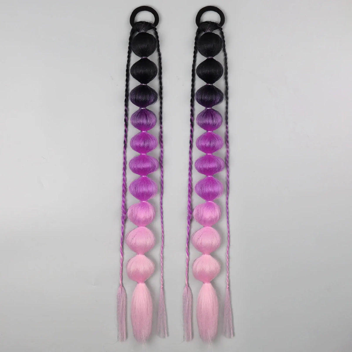 Synthetic bubble ponytail extensions from Corporación Turística, shown in a close-up with shiny black strands.