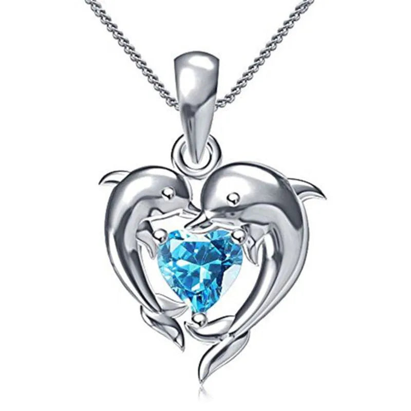 Sterling silver 925 dolphin and heart-shaped pendant necklace by Corporación Turística, close-up of detailed jewelry.