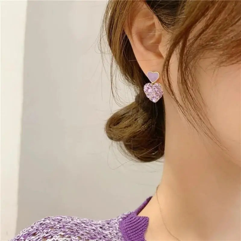 Purple crystal heart drop earrings for women, elegant jewelry by Corporación Turística, featuring sparkling gemstone accents.
