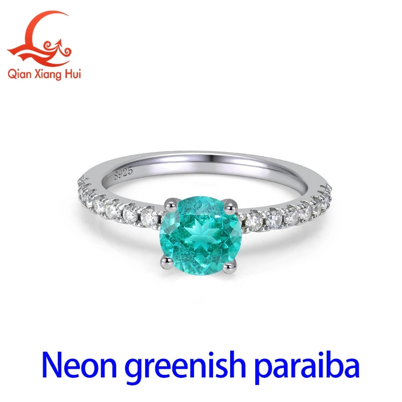 Silver ring featuring a 6.5mm Neon Blue Paraiba Tourmaline with greenish hue, set in a sleek design.