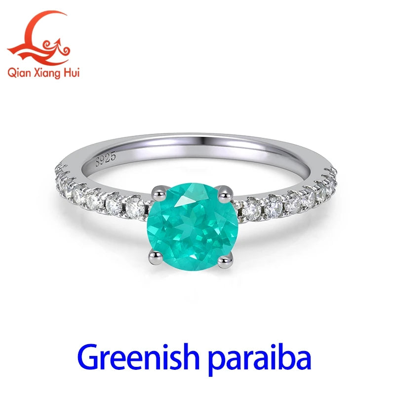 Silver ring with a 6.5mm neon blue-green Paraiba tourmaline gemstone, set in a sleek and polished band.