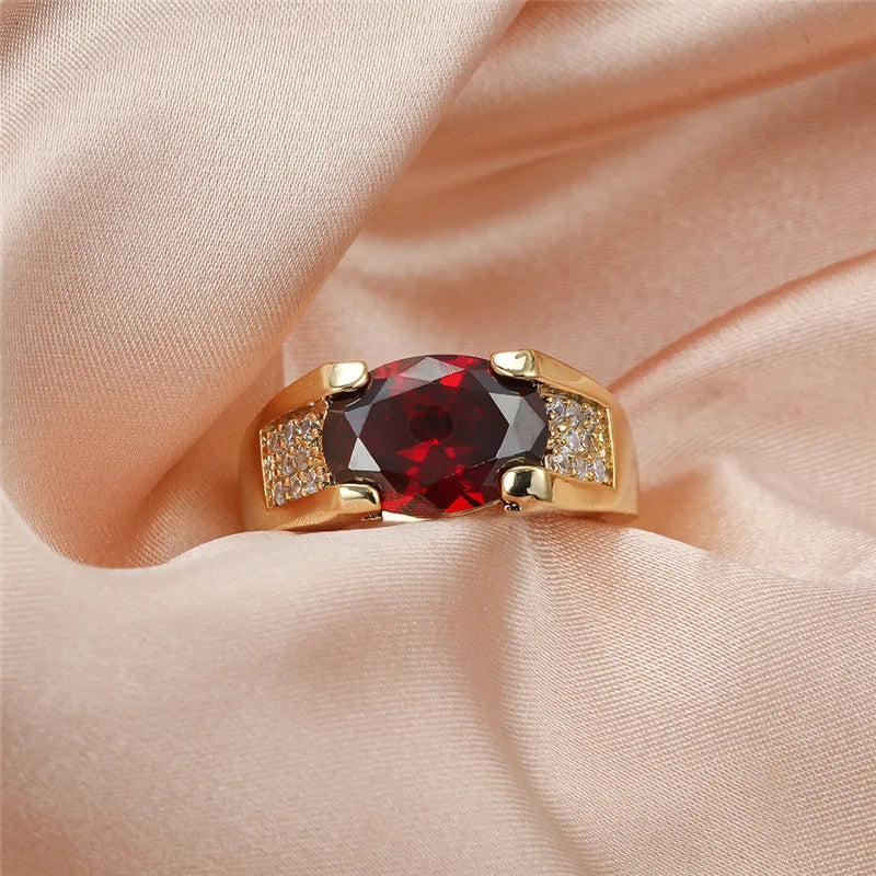 Elegant red crystal ring with oval zirconia, luxurious jewelry piece from Corporación Turística, showcasing detailed design and sparkle.