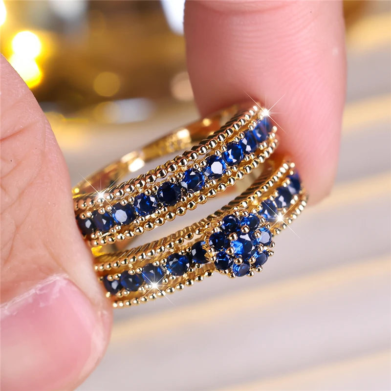 Set of engagement rings featuring blue zircon stones, crafted by Corporación Turística, showcasing elegant gemstone designs.