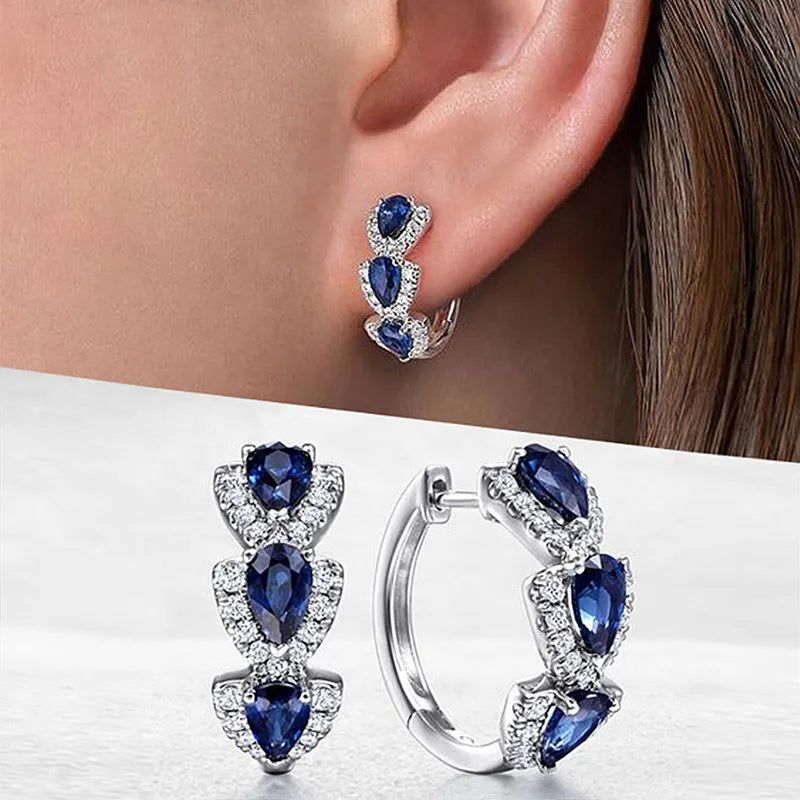 Sterling silver hoop earrings with cubic zirconia from Corporación Turística, featuring sparkling stone details.