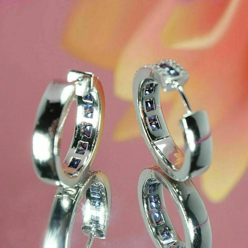 Sterling silver hoop earrings with cubic zirconia from Corporación Turística, showcasing shiny, elegant jewelry design.
