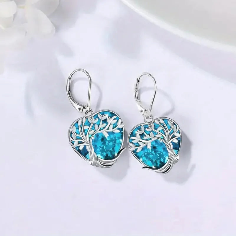 Blue crystal heart-shaped dangling earrings by Corporación Turística, showcasing elegant jewelry design.