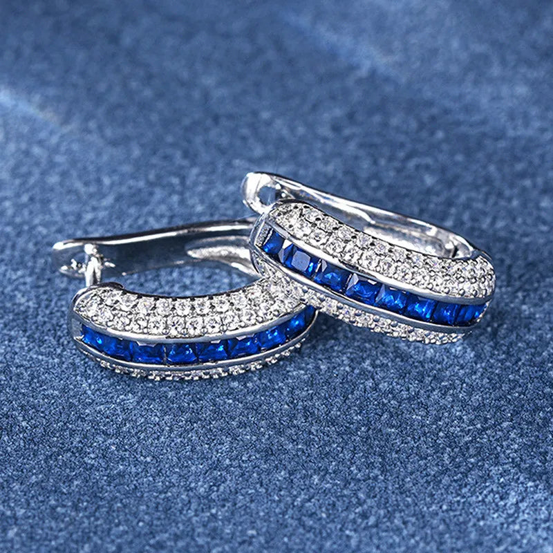 Sterling silver hoop earrings with cubic zirconia from Corporación Turística, showcasing shiny, elegant jewelry design.