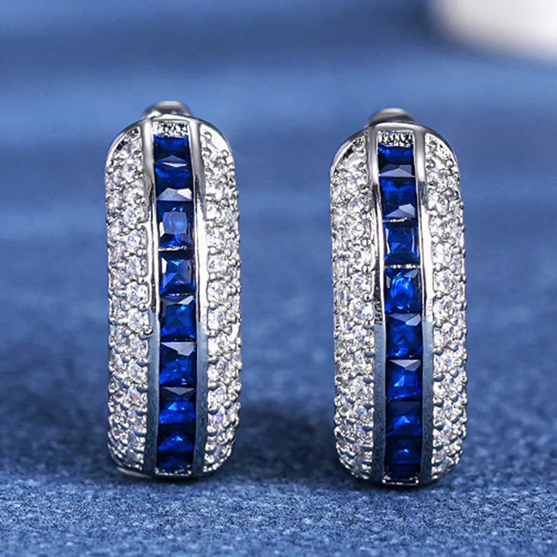 Sterling silver hoop earrings with cubic zirconia by Corporación Turística, showcasing shiny round design and sparkling stones.