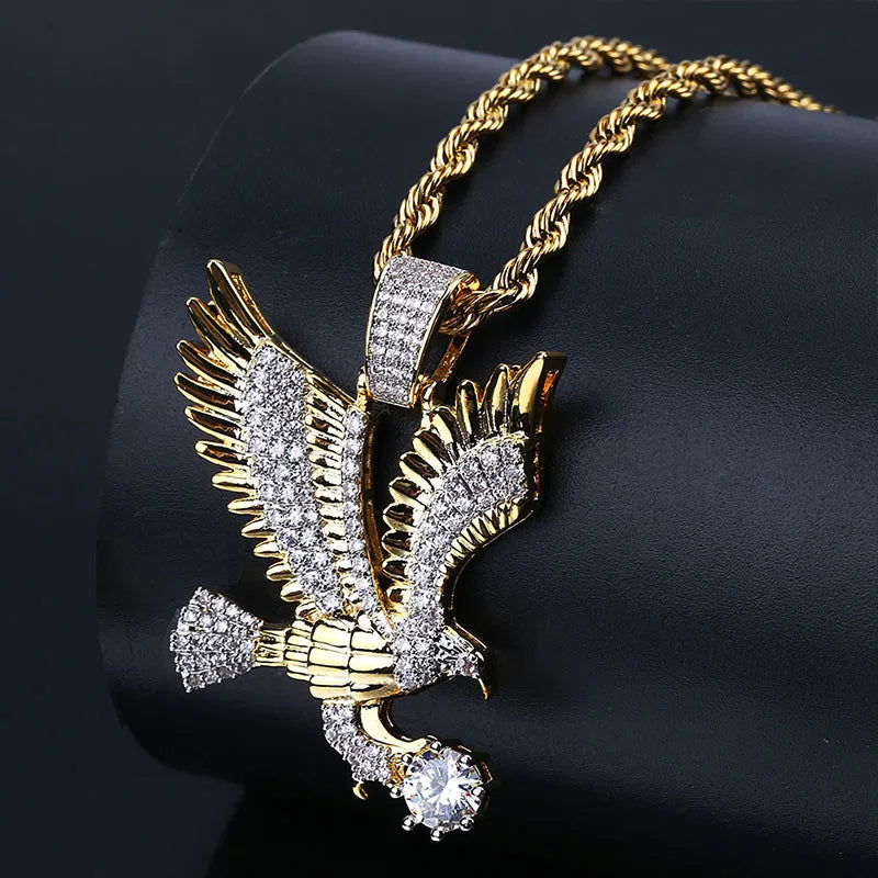 Gold-colored eagle pendant on a black cord necklace, featuring a detailed flying eagle design from Corporación Turística.