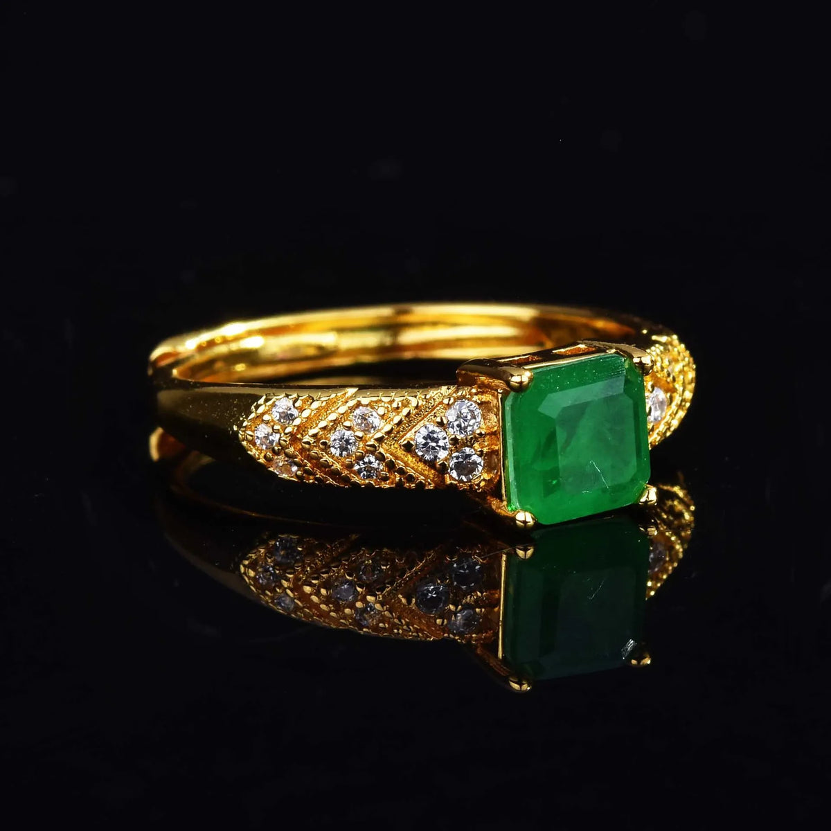 18K gold women's ring with a natural emerald gemstone, featuring a sleek band and elegant design.