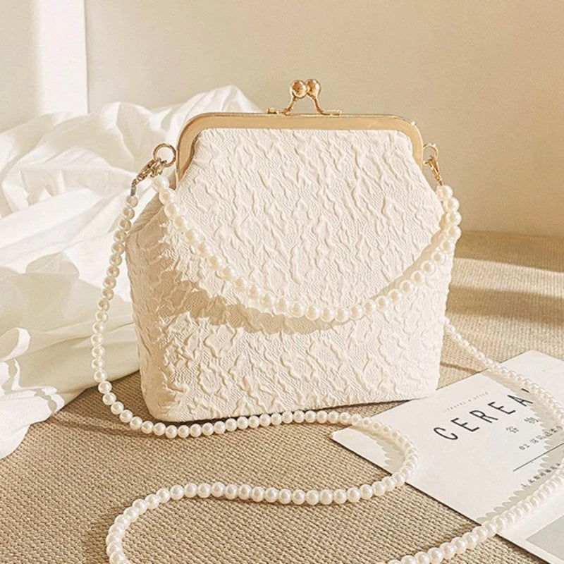 Beige crossbody phone bag with chain strap by Corporación Turística, featuring a compact design and stylish look.