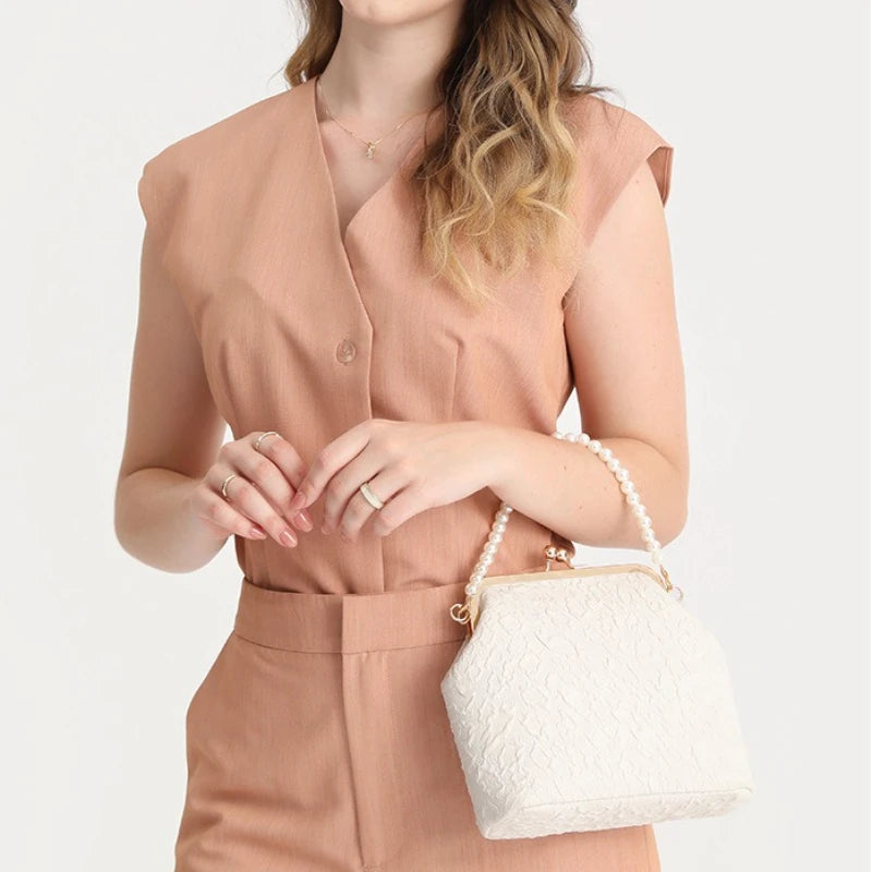 Beige crossbody phone bag with chain strap, compact design, ideal for carrying mobile devices and small essentials.