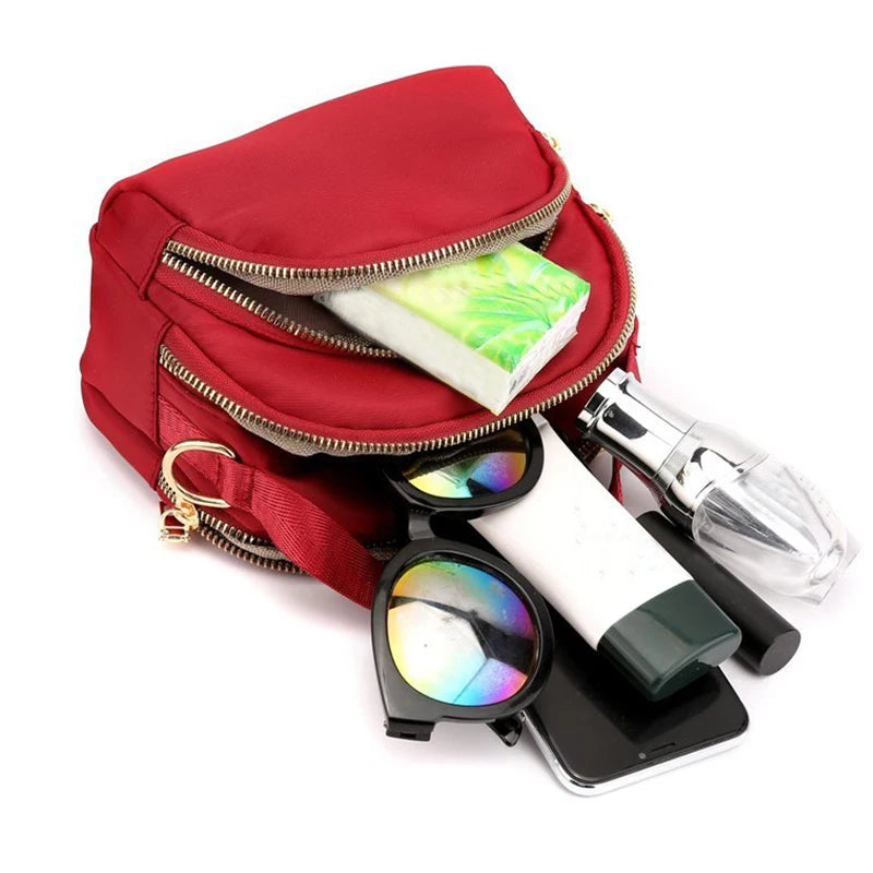 Red versatile and modern shoulder bag for men and women by Corporación Turística, featuring a sleek design and adjustable strap.