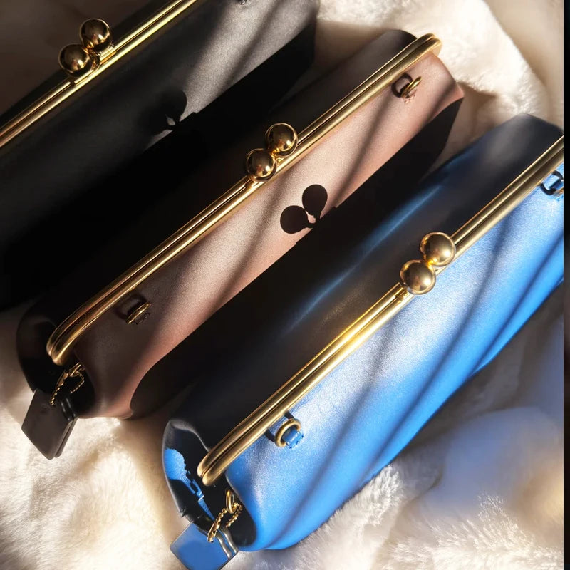 Black classic kiss-lock closure handbag for women, 30 cm long, with sleek design and structured shape.