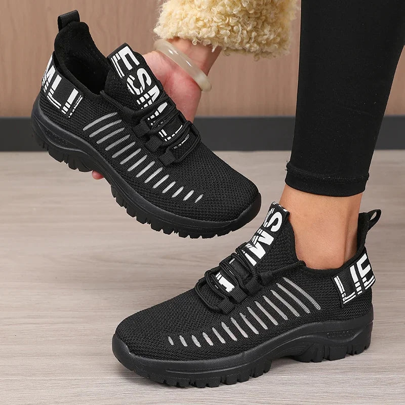 Black men's 2025 fashion mesh running shoes by Corporación Turística, featuring breathable fabric and sporty design.