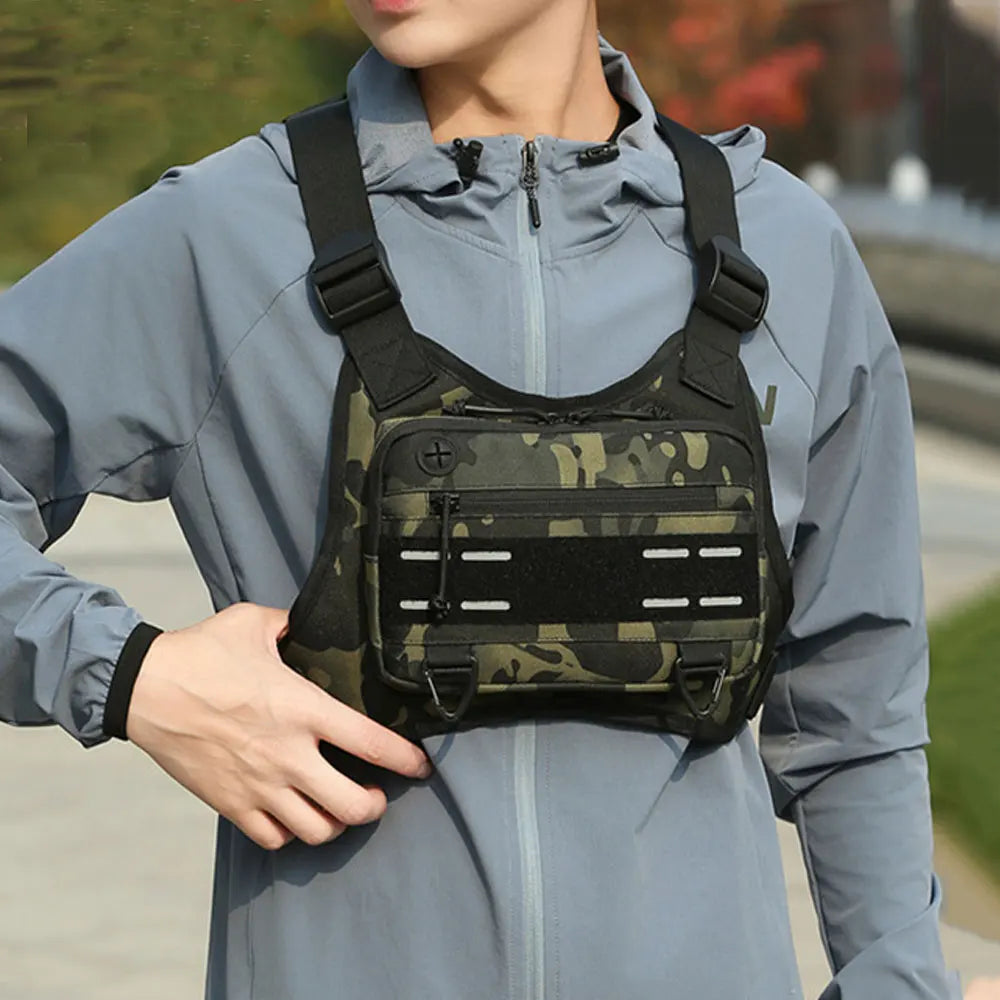 Black tactical vest with chest pouch and camping backpack, designed for outdoor adventures by Corporación Turística.