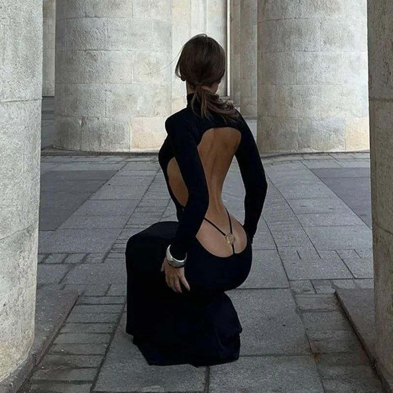 Black long evening dress with a mid-height collar, designed by Corporación Turística, shown on a model.