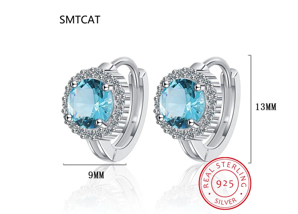 Silver 925 oval hoop earrings with blue sapphire stones, elegant jewelry by Corporación Turística.