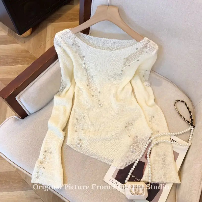 Black women's sweater with open knit design and bead detail, featuring a stylish hole pattern and relaxed fit.