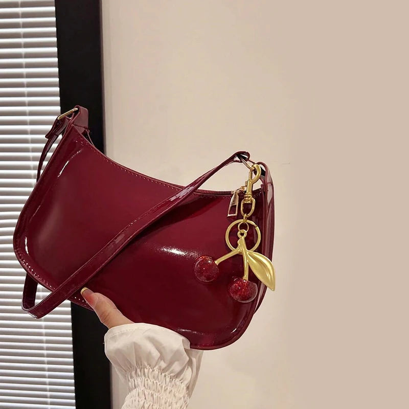 White synthetic leather women's handbag with shoulder strap, stylish and versatile for everyday use.