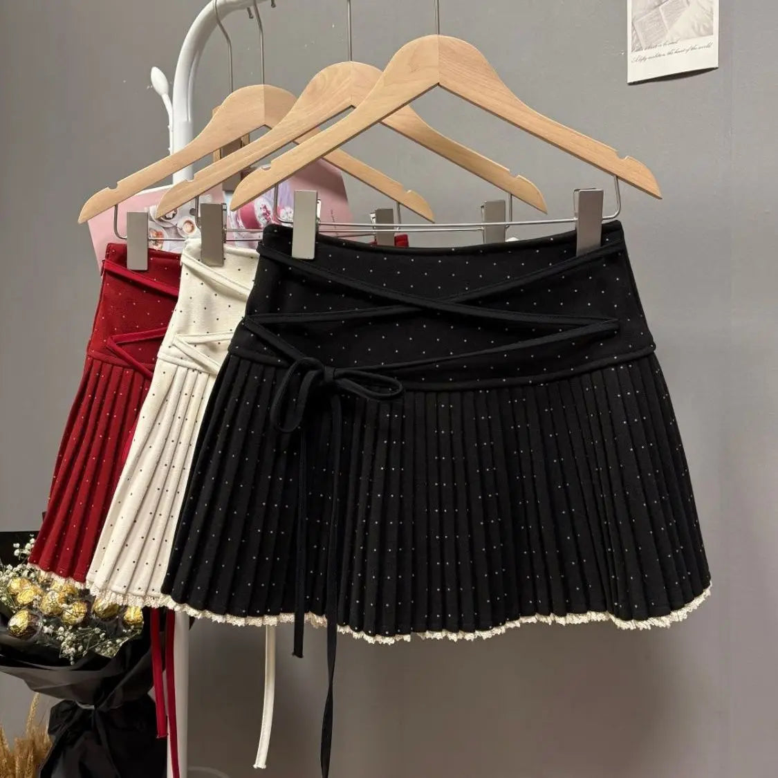 White 2026 Nueva Falda plisada with crossed polka dot straps from Corporación Turística, shown with pleated design and stylish details.