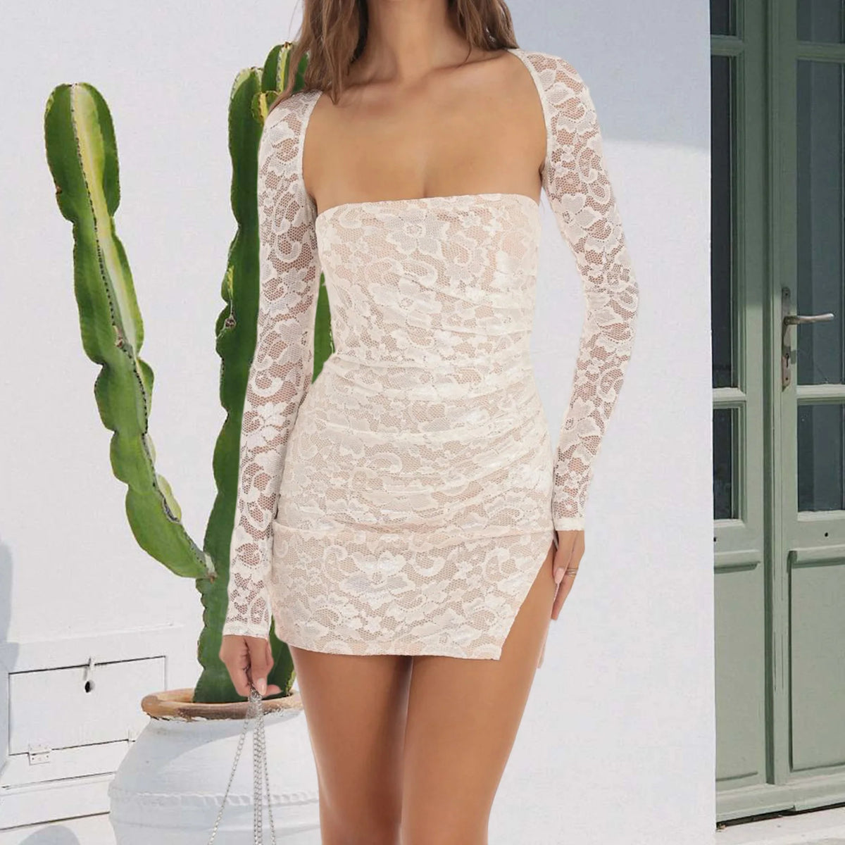 White fitted women's dress with lace slit, designed by Corporación Turística, featuring a stylish, form-fitting silhouette and elegant lace detail.