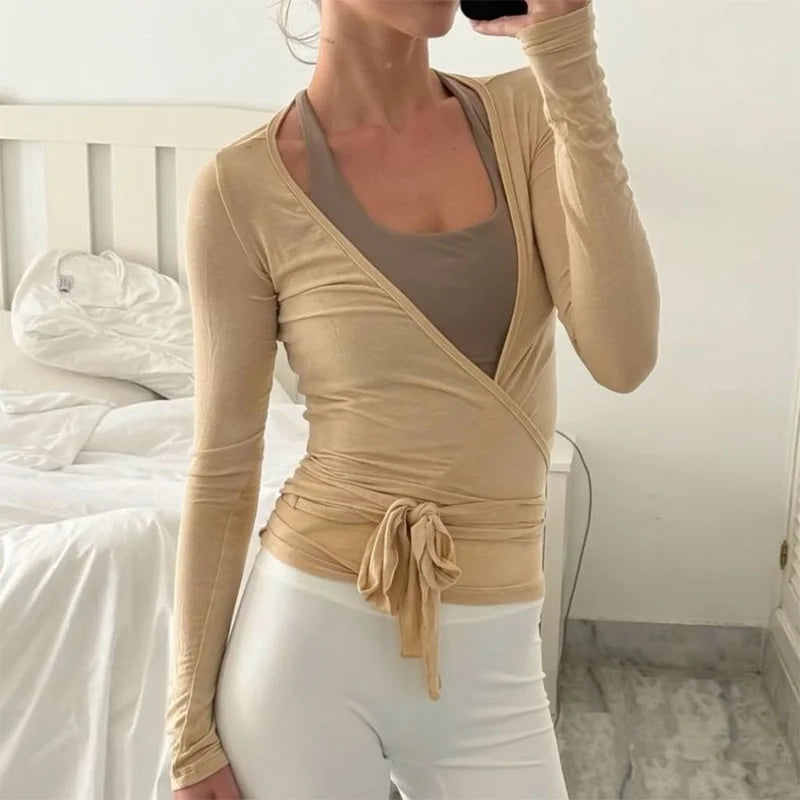 White women's yoga crop top with a crossed tie design, made by Corporación Turística, featuring a stylish and comfortable fit.