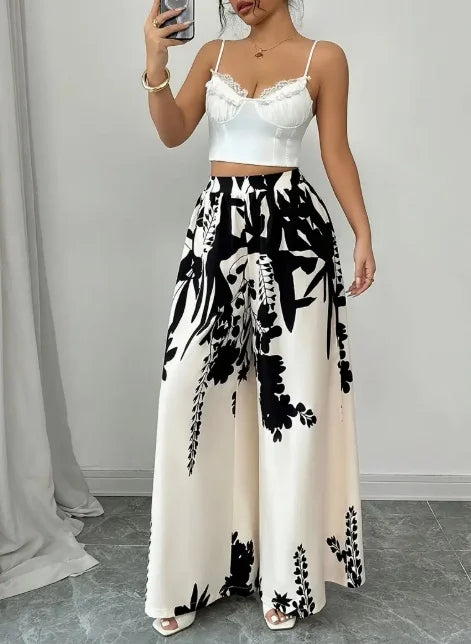 White silky floral print wide-leg pants from Corporación Turística, featuring a relaxed fit and elegant design.
