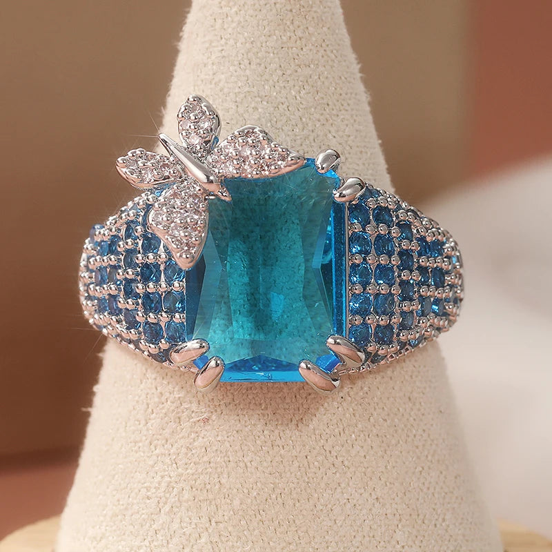 Elegant blue topaz cocktail ring by Butterfly featuring a detailed butterfly design and sparkling gemstone accent.