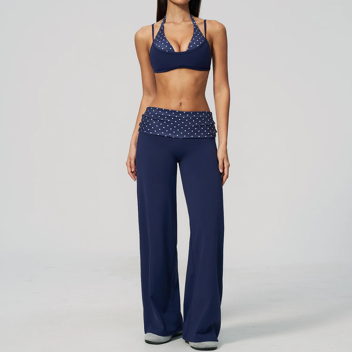 Brown polka dot 2-piece yoga set by Corporación Turística, including a sports bra and leggings for women, on white background.