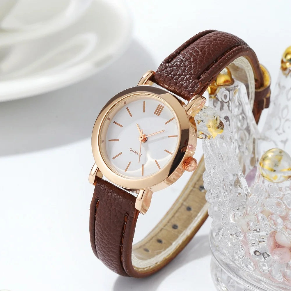 Minimalist women's quartz watch by Corporación Turística with a white dial and brown strap, elegant and simple design.