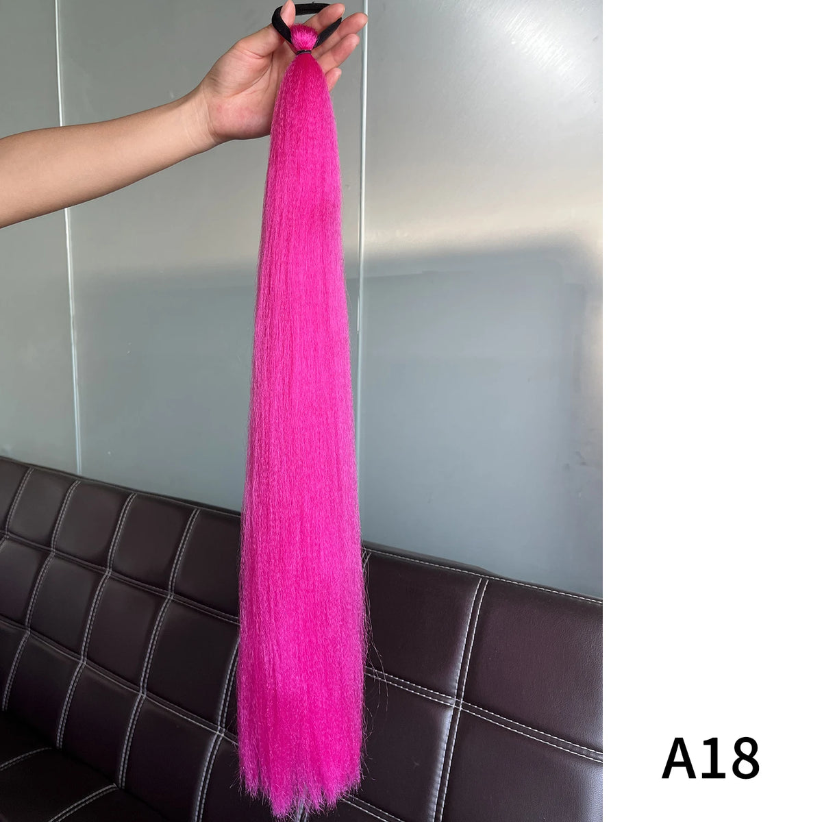 Purple synthetic ponytail extension with band, 26-28 inches long, by Corporación Turística, shown in a close-up view.