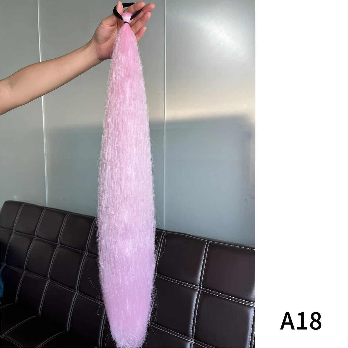 Purple synthetic ponytail extension with band, 26-28 inches long, by Corporación Turística, shown styled with hair tied back.