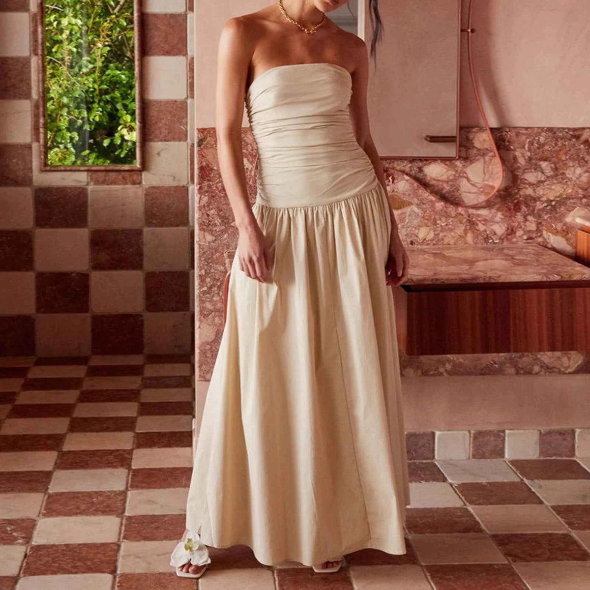 Elegant long strapless women's dress in caqui from Corporación Turística, displayed on a hanger.