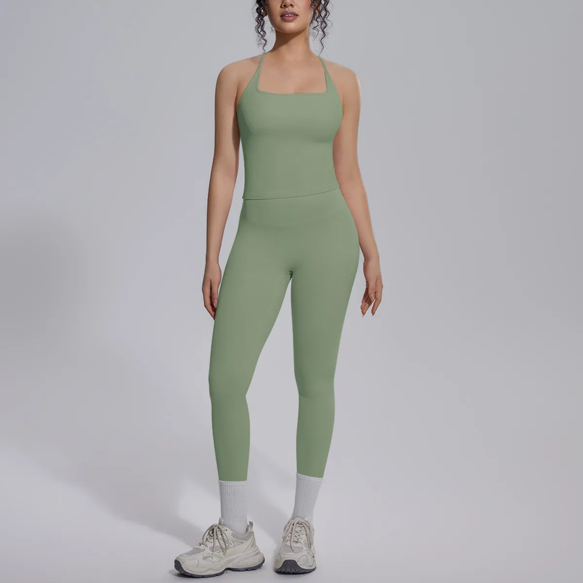 Green women's yoga set with a crop top and high-waisted leggings, made by Corporación Turística for active gym wear.