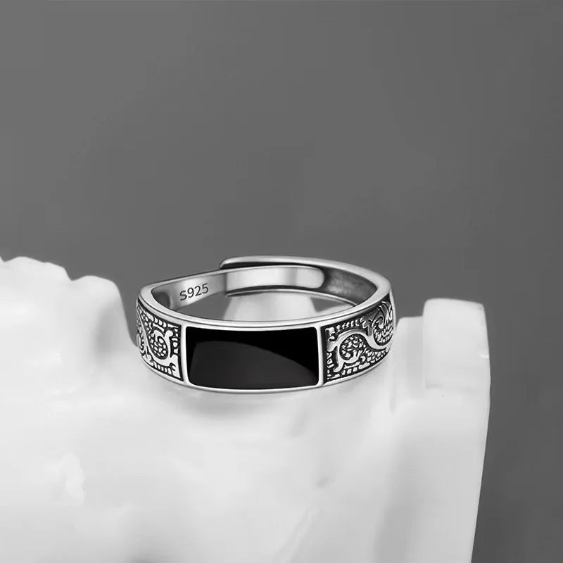 Sterling silver 925 men's ring with a striking black gem, showcasing a sleek and modern jewelry design.