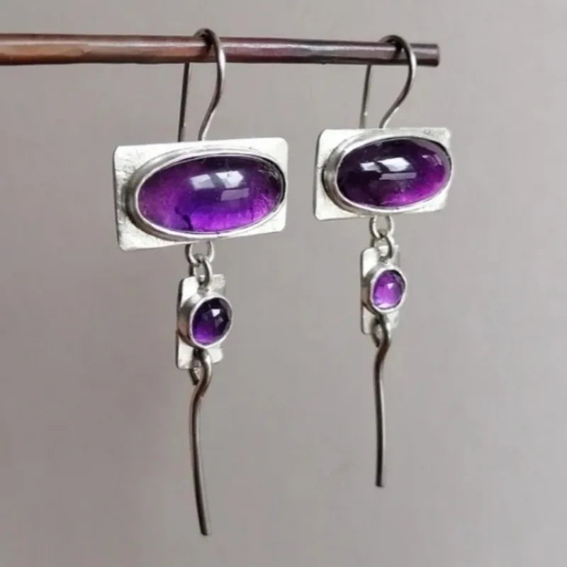 Vintage oval design earrings with intricate gemstone inlays, crafted by Corporación Turística, featuring elegant, detailed jewelry.