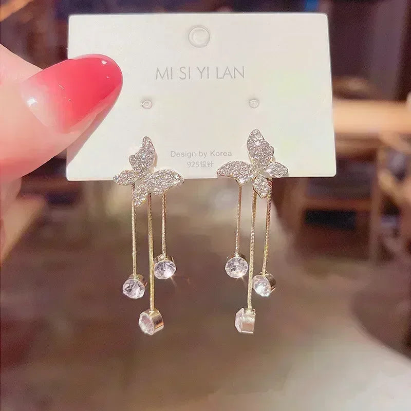 Square crystal zirconia earrings in warm brown from Corporación Turística, shown close-up with shiny, faceted stones.