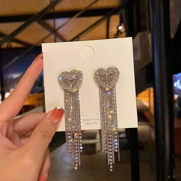 Exquisitos pendientes colgantes de cristal en forma de gota, en color blanco, con diseño elegante y brillante.