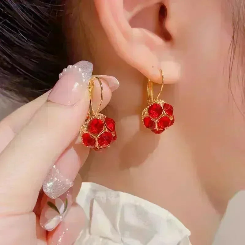 Exquisitos pendientes colgantes de cristal en forma de gota, diseñados por Corporación Turística, con acabado en color blanco brillante.