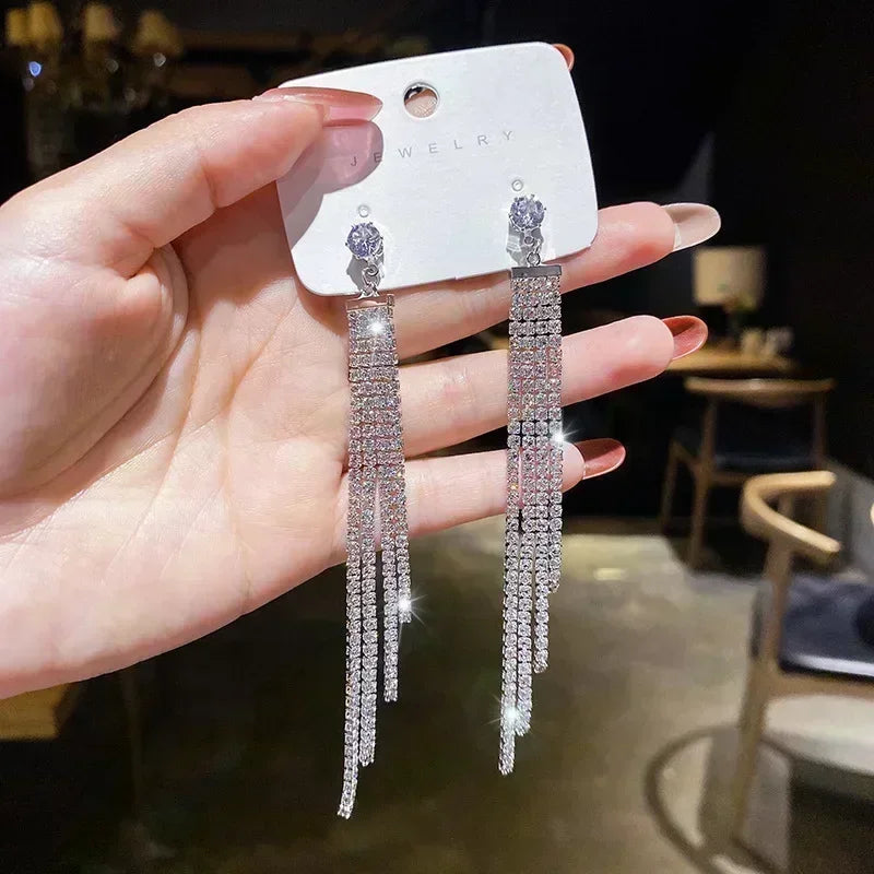 Exquisitos pendientes colgantes de cristal en forma de gota, en color blanco, diseñados por Corporación Turística.