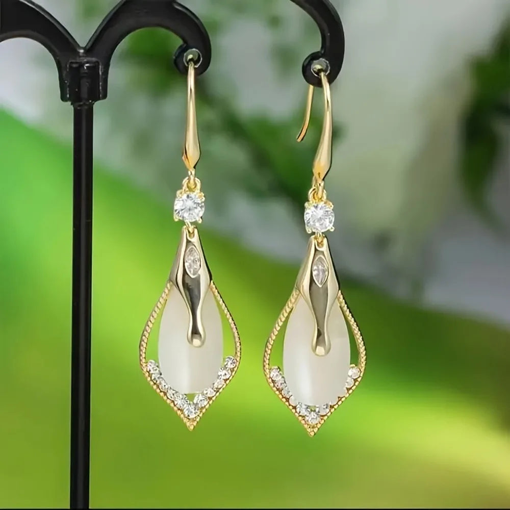 Exquisite cat's eye stone dangling earrings from Corporación Turística, showcasing polished gemstone pendants with silver hooks.