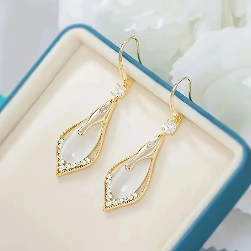 Exquisitos pendientes colgantes de piedra de ojo de gato de Corporación Turística, con detalles elegantes y llamativos.