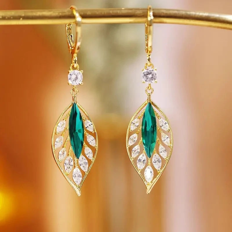 Gold leaf crystal earrings for women featuring green crystals, elegant jewelry accessory with leaf design.