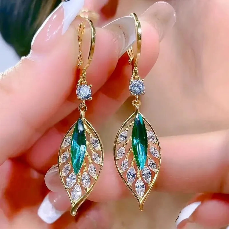 Gold leaf crystal earrings for women featuring green crystals, stylish and elegant jewelry by Corporación Turística.