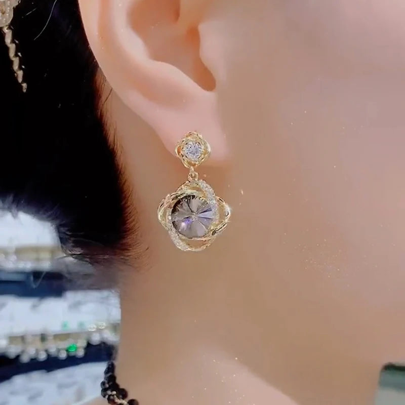 Elegant earrings with round crystal pendants wrapped in delicate silver, designed by Corporación Turística.