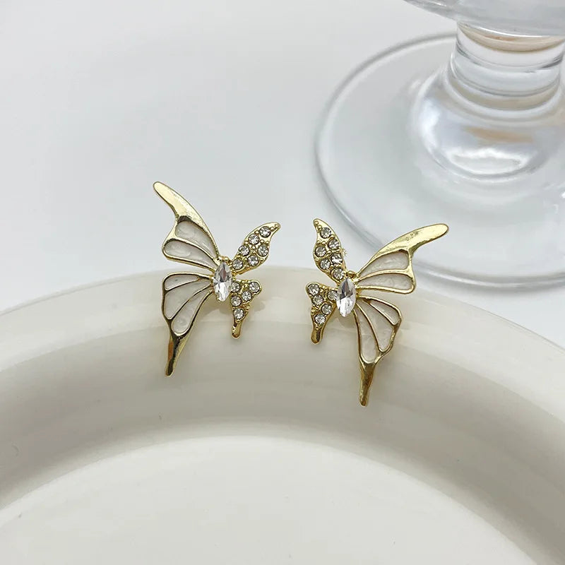 Elegant butterfly-shaped fashion earrings for women, featuring colorful designs and silver hooks, by Corporación Turística.