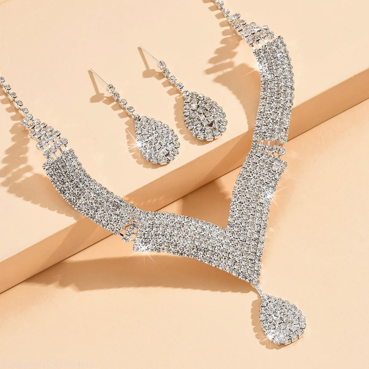Fashion jewelry set with drop-shaped rhinestones, featuring gold-tone finish, including earrings and necklace from Corporación Turística.